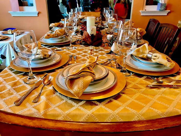 Photo 1. Family gathering, photo by Ken S on Unsplash, showing a table full of plates for a family.